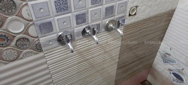 Three faucet installed on a wall in a Bathroom